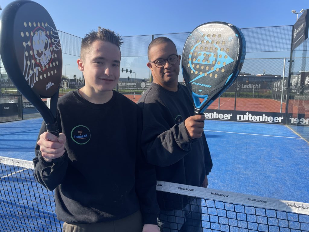 Twee cliënten bij de padel baan.  