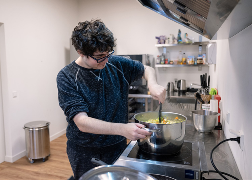 Jongen die eten kookt.