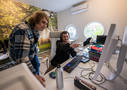 Twee jongens werken achter de computer.